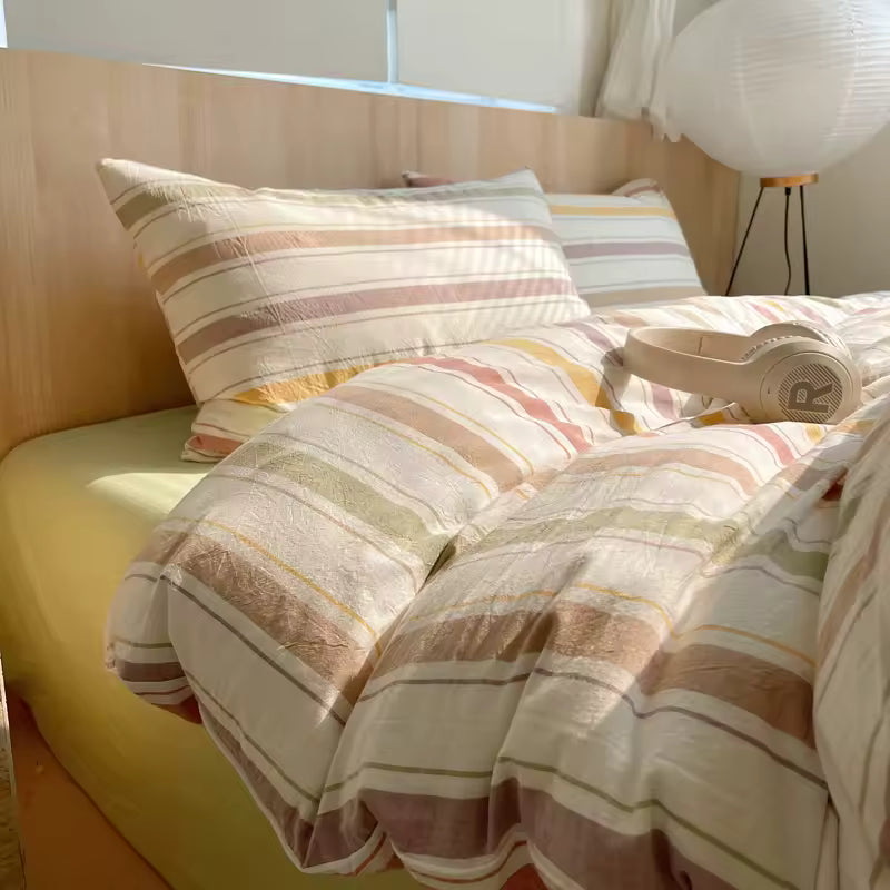 Bed with striped bedding and pillows in a bedroom setting