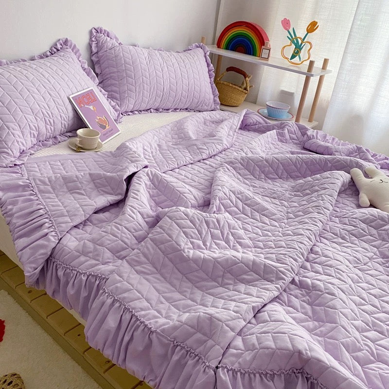 Solid color quilted bedding set with delicate ruffle trim