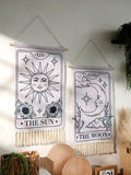 Boho bedroom setup with sun and moon tarot tapestries styled above spiritual objects.