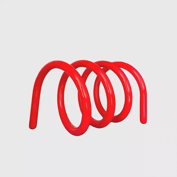 Modern spring metal book rack displayed on desk, holding books upright in minimalist Nordic aesthetic living room decor.