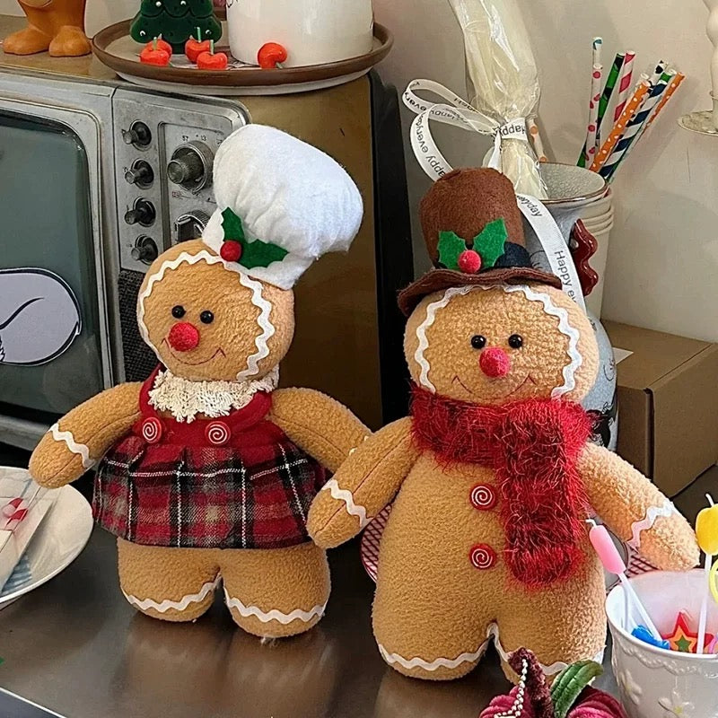 Standing gingerbread doll pair in brown with a red scarf, plaid skirt, white chef hat and brown top hat.