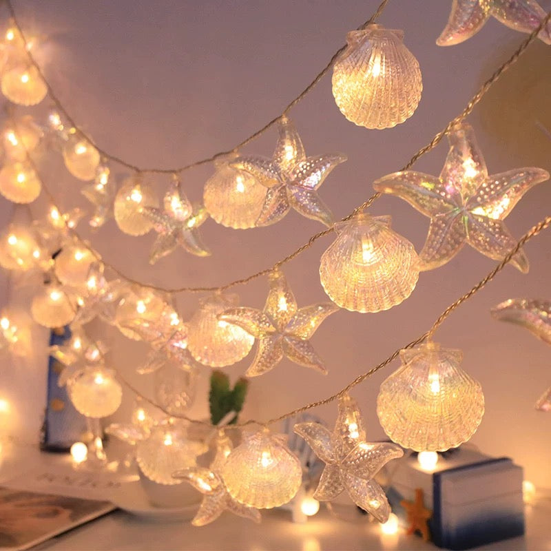 String lights with shell and starfish decorations on a ceiling