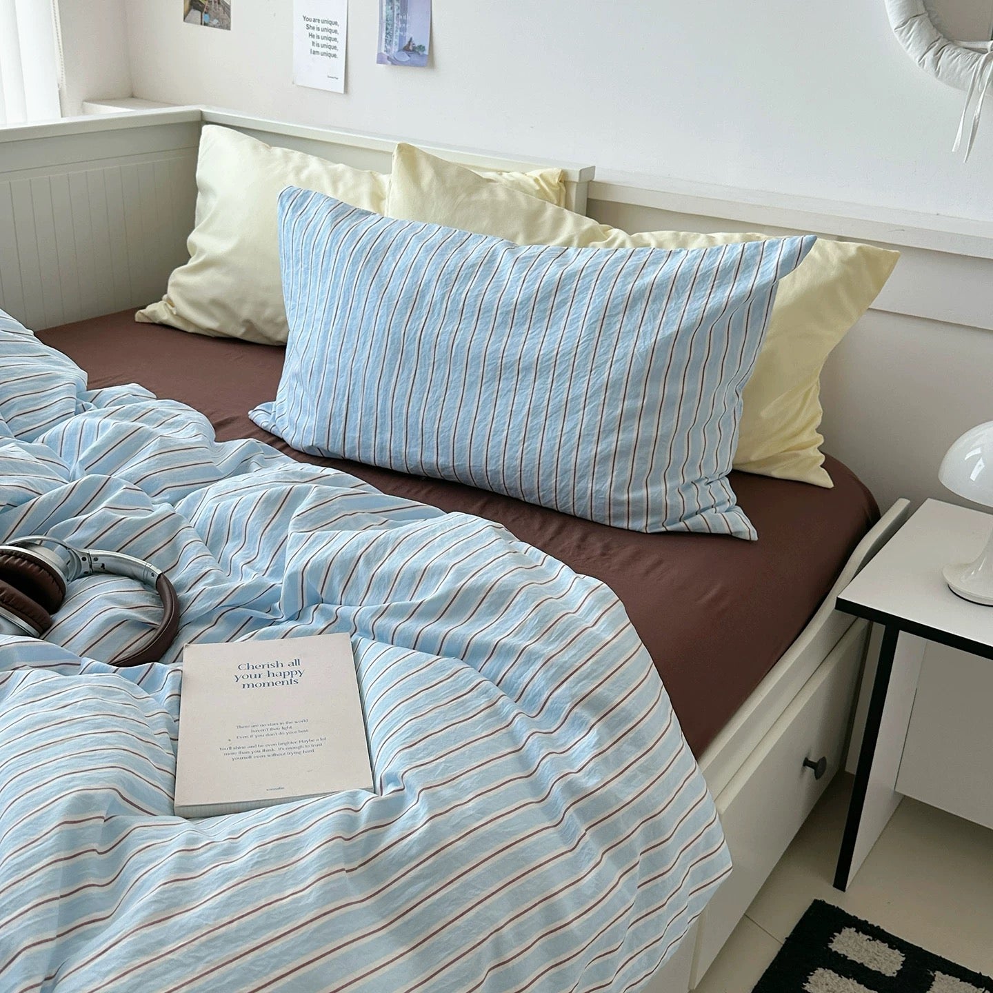 Bed with striped bedding and pillows in a bedroom setting