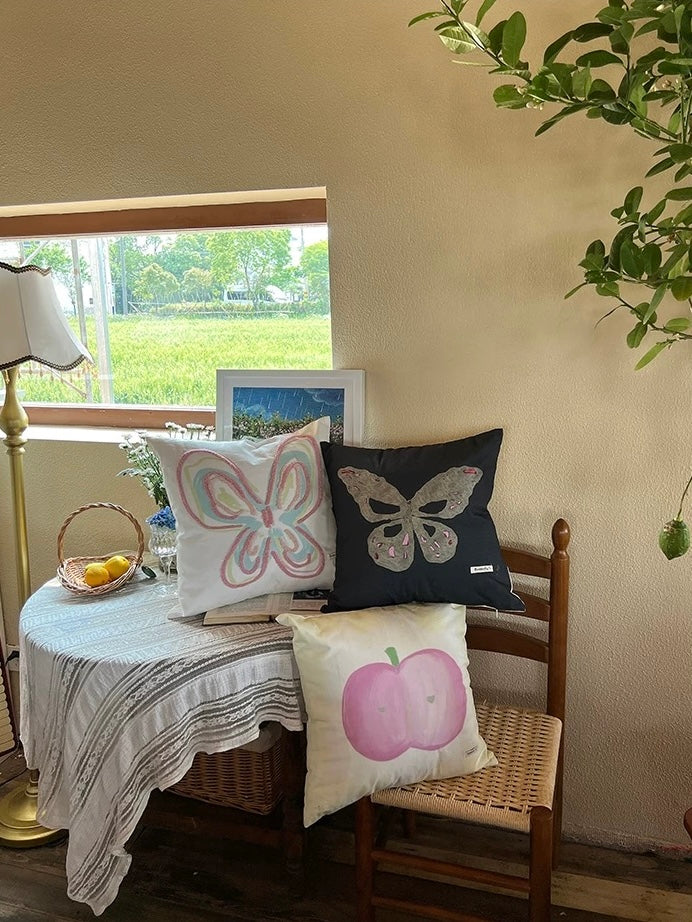 Embroidered canvas throw pillow set of 3 in butterfly and apple designs by a window