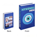 Overhead shot of stacked pastel travel books featuring destinations like Mexico and Miami.