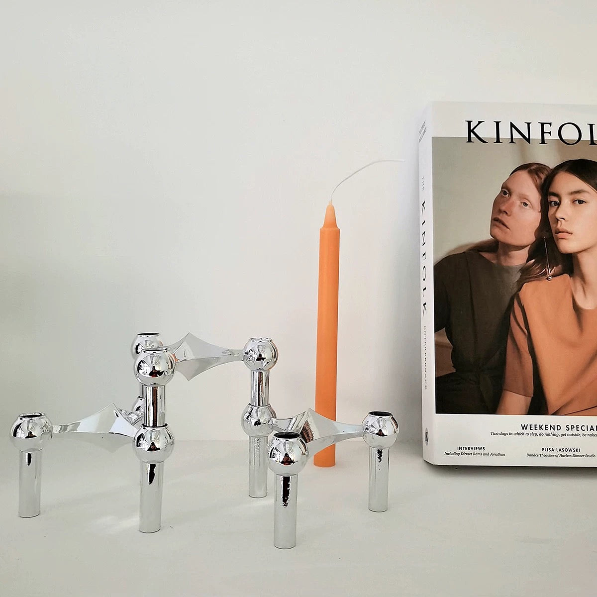 The candlestick holding a lit candle, casting a warm glow.