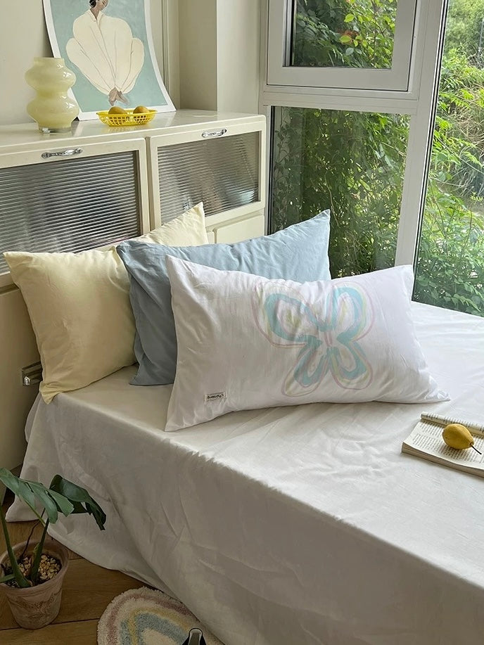 White butterfly pillowcase styled with soft yellow and blue accents.