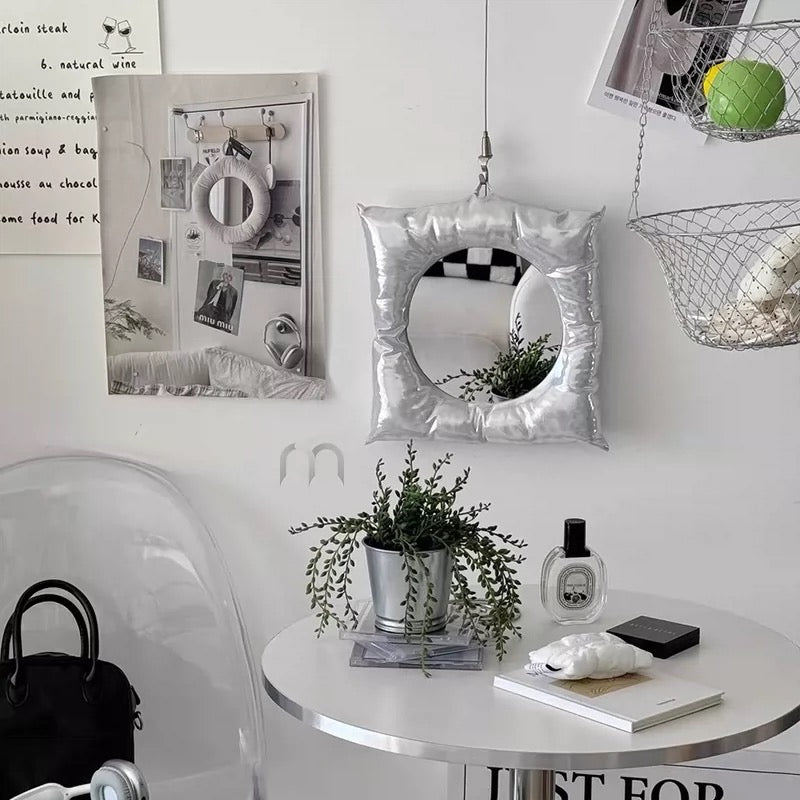 Modern interior with decorative mirror, plants, and a table.