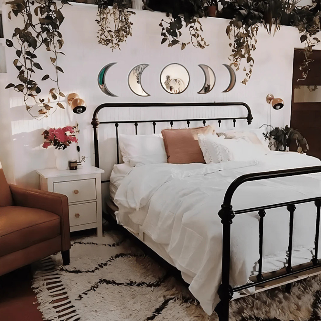 Beige moon mirrors arranged in lunar order above a cozy bed with fairy lights