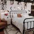 Beige moon mirrors arranged in lunar order above a cozy bed with fairy lights