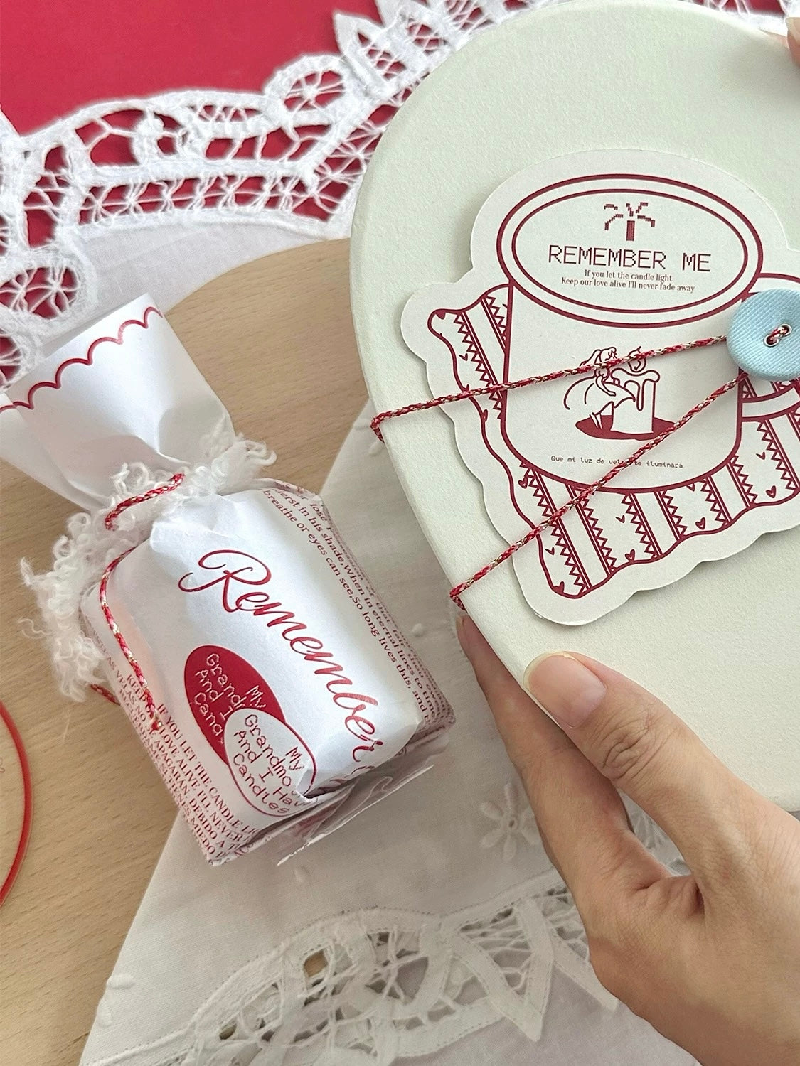 Wrapped Christmas scented candle held beside its gift packaging