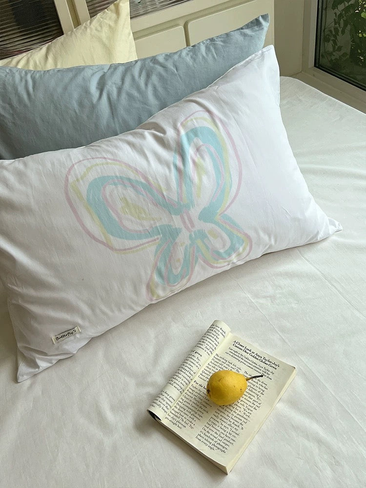 Pastel butterfly line art printed on a white pillowcase.