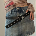 Person wearing a black belt with star designs on blue jeans.