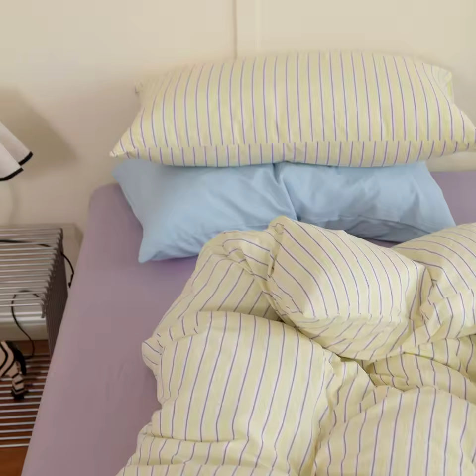 Bed with striped bedding and pillows in a bedroom setting