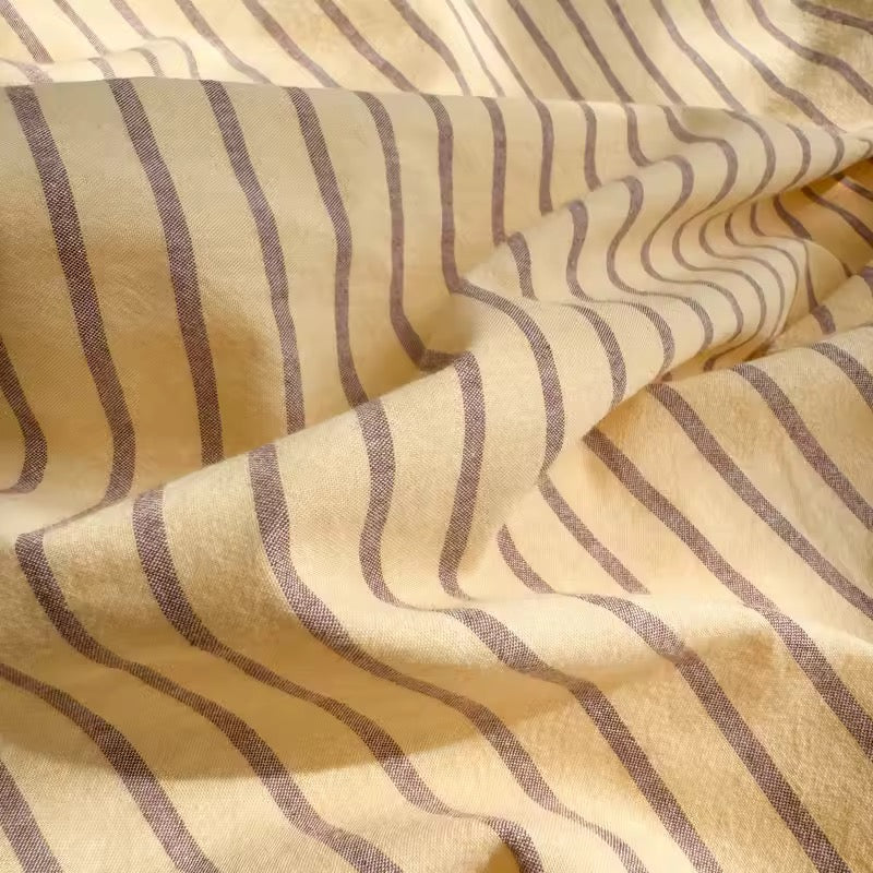 Scandinavian yellow striped bedding for modern bedroom interiors.